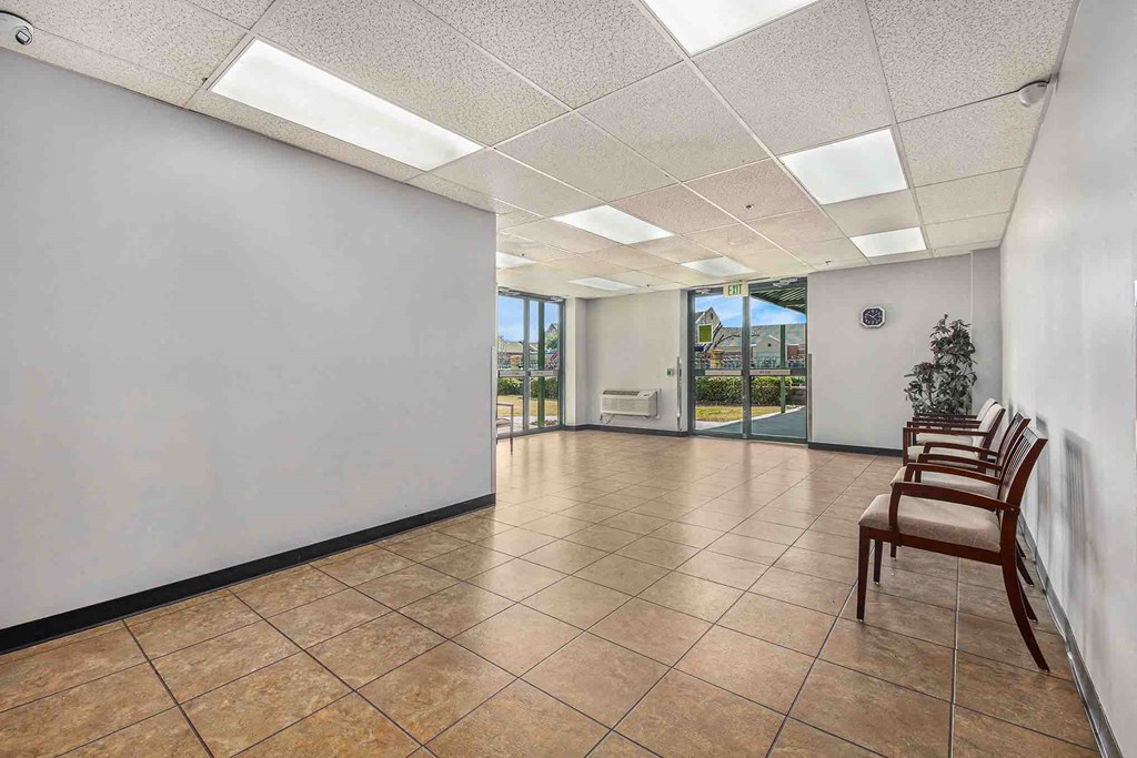 a lobby with chairs and a white wall in a building
