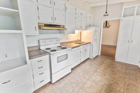 A kitchen with white cabinets and appliances.