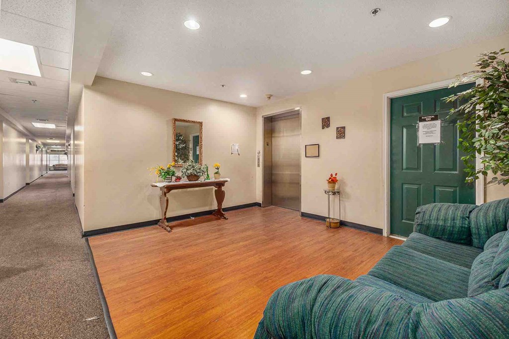 a room with a couch and a table in front of a green door