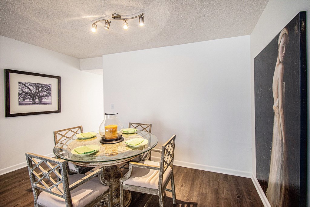 A dining room with a glass table and chairs.