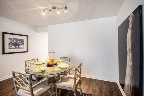 A dining room with a glass table and chairs.