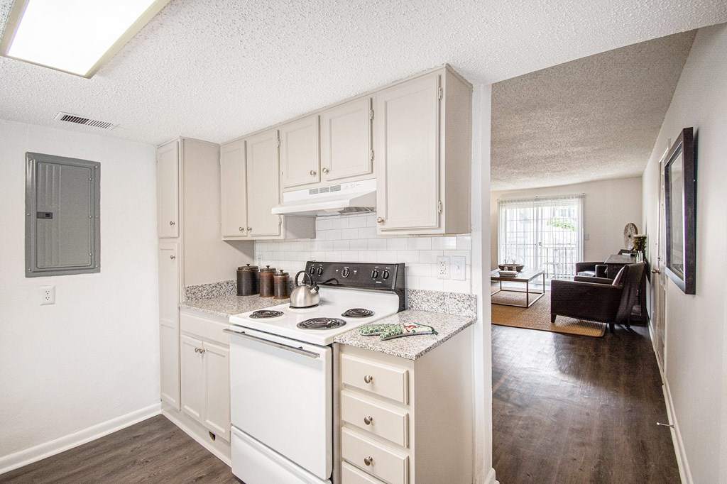 A kitchen with white appliances and cabinets.
