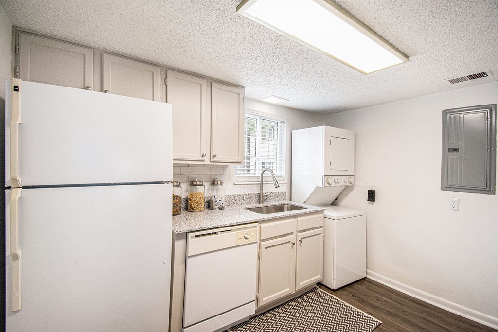 A kitchen with white appliances and cabinets.