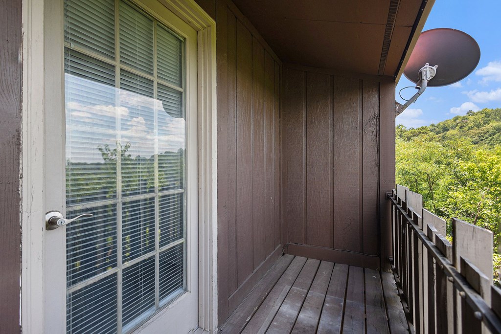 a balcony with a view of trees and a blue sky