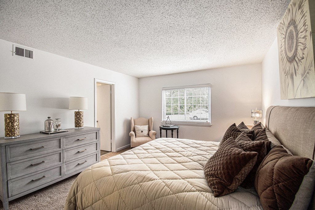 A bedroom with a large bed and a window.