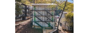 a building with stairs and green doors    and trees