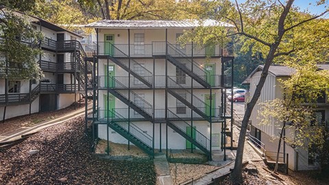 a building with stairs and green doors    and trees