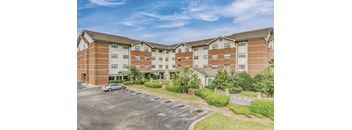 an exterior view of an apartment building with a parking lot