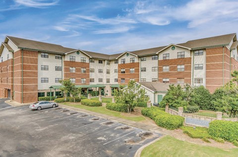 an exterior view of an apartment building with a parking lot