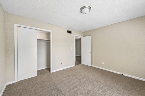 A room with carpeted floor and two doors.