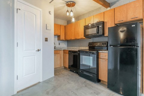 an empty kitchen with black appliances and wood cabinets