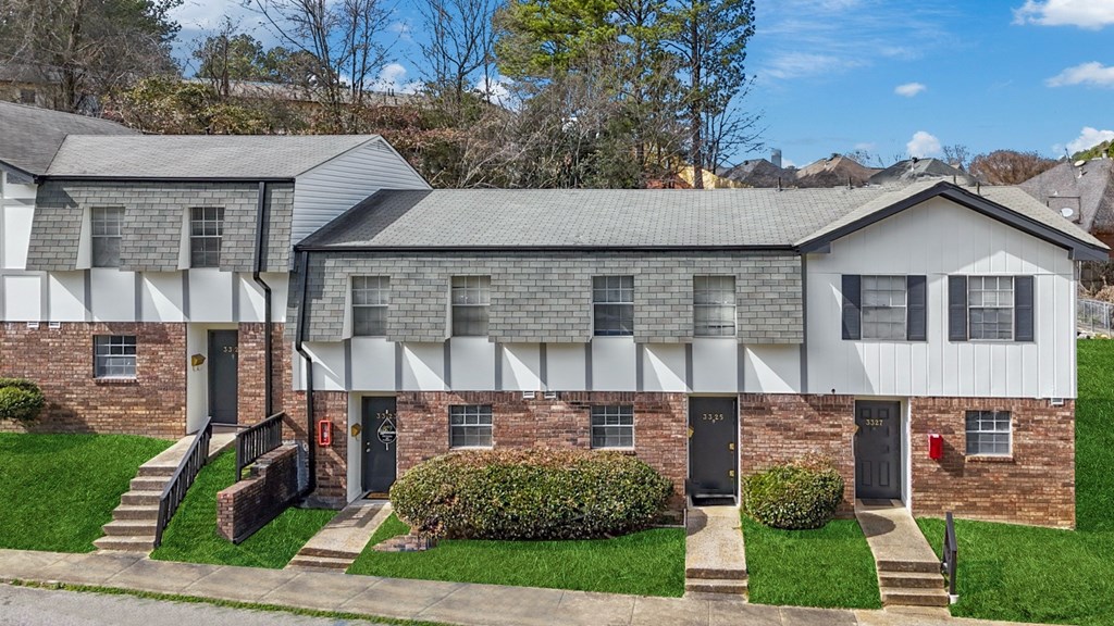 A row of houses with a green lawn in front.