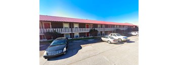 the building where the motel is located has cars parked in front of it