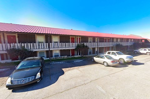 the building where the motel is located has cars parked in front of it