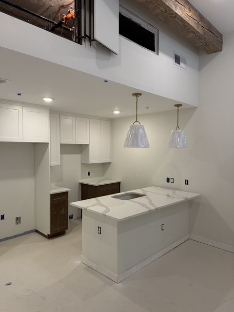 A kitchen with white countertops and wooden cabinets.