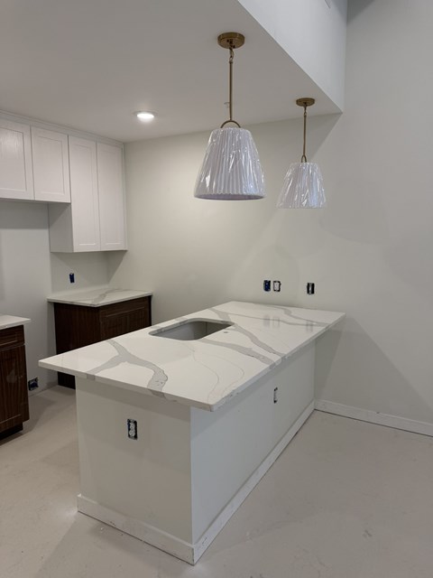 A kitchen with a white countertop and a sink.
