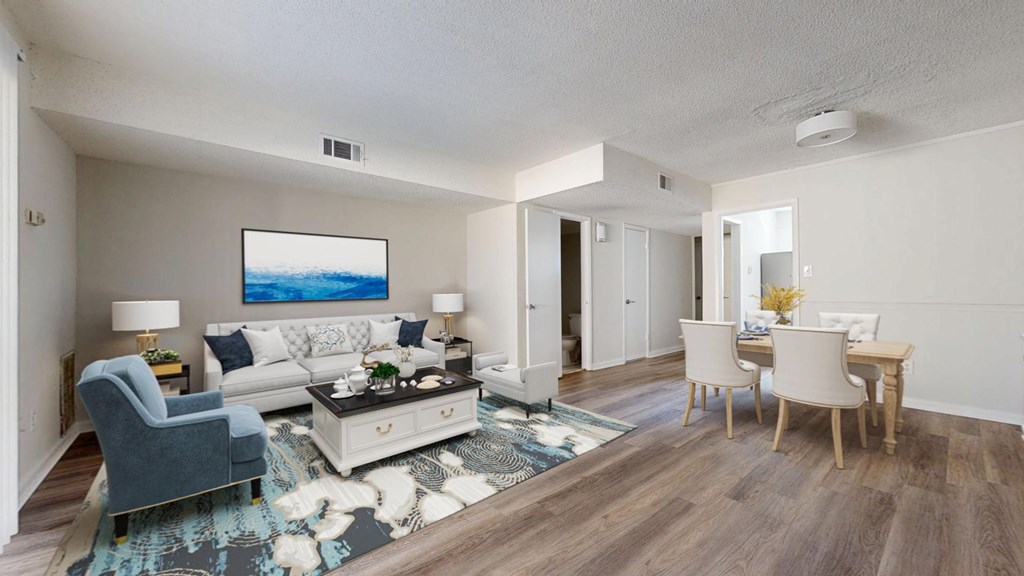 A living room with a grey sofa, a white coffee table, and a painting on the wall.