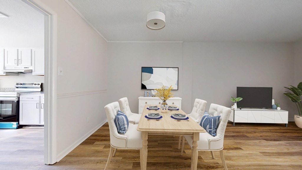 A dining room with a wooden table and white chairs.