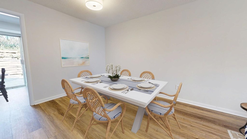 A dining room with a white table and chairs.