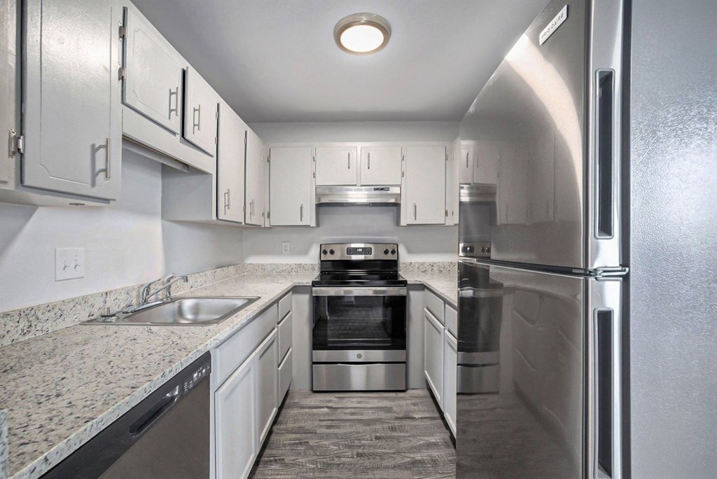 a kitchen with white cabinets and stainless steel appliances