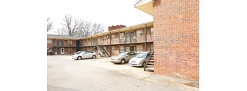 a parking lot with cars in front of a brick building