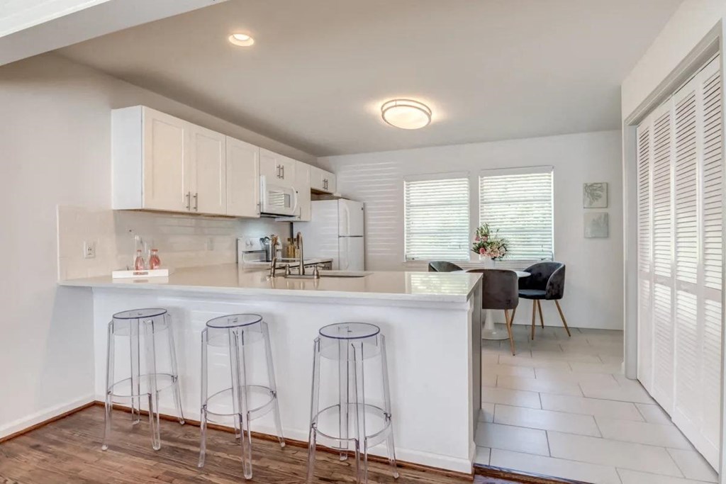 a kitchen with a bar and stools in front of a counter top