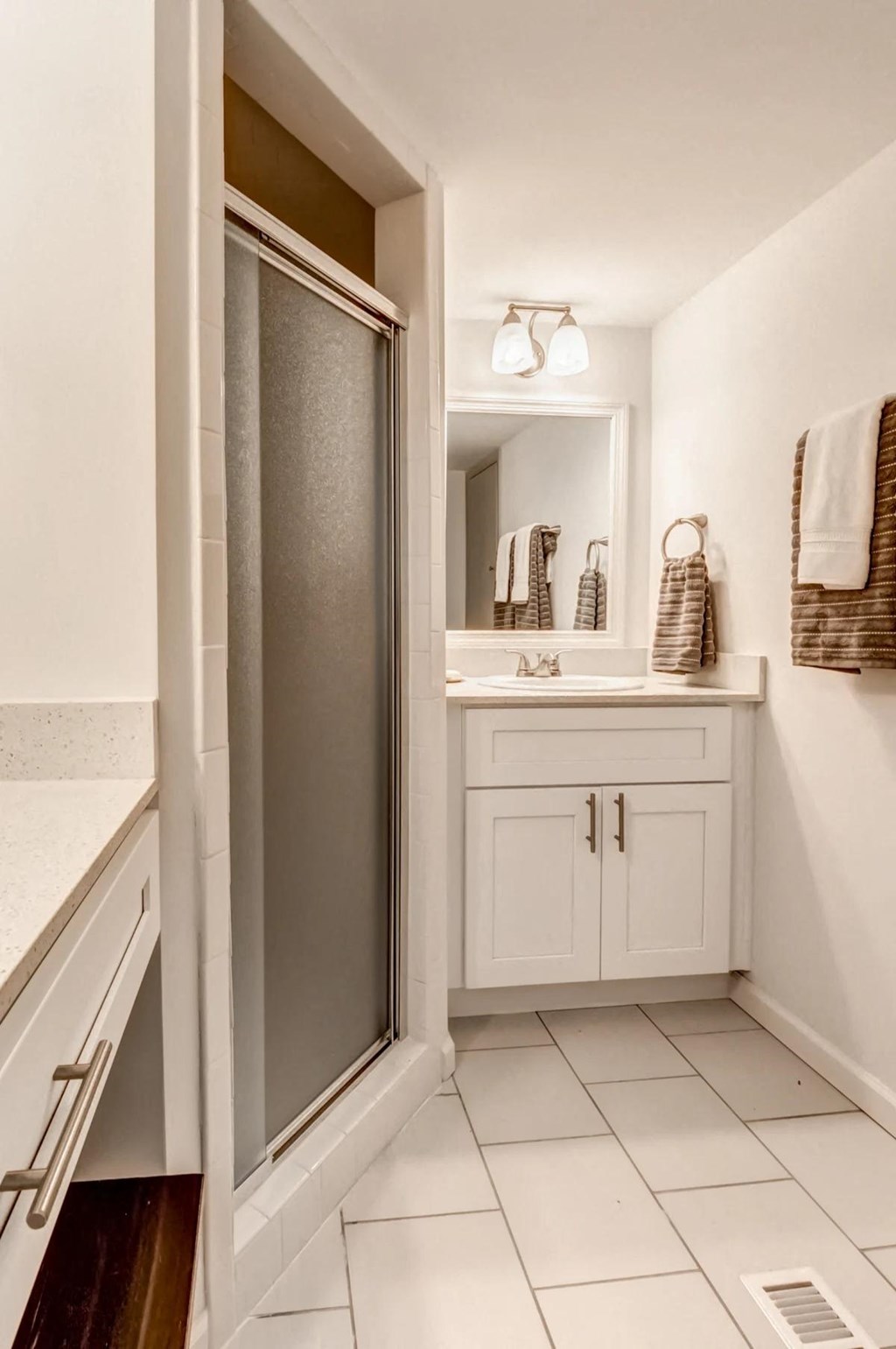 a bathroom with a shower and a sink and a mirror