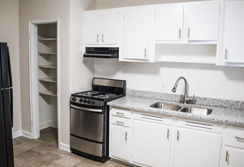 A kitchen with white cabinets and a black stove top oven.