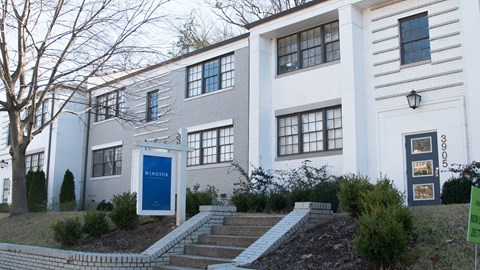 A white building with a blue door and windows.