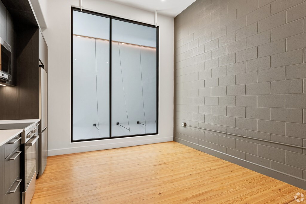 A kitchen with wooden floors and a grey wall.