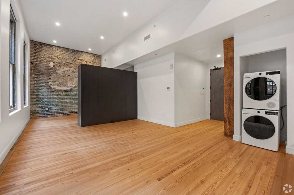 A room with wooden floors and a brick wall.