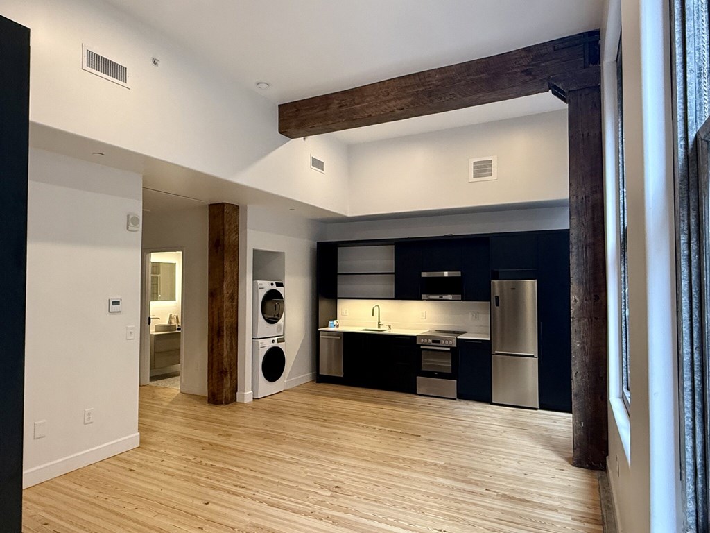 A modern kitchen with dark blue cabinets and stainless steel appliances.