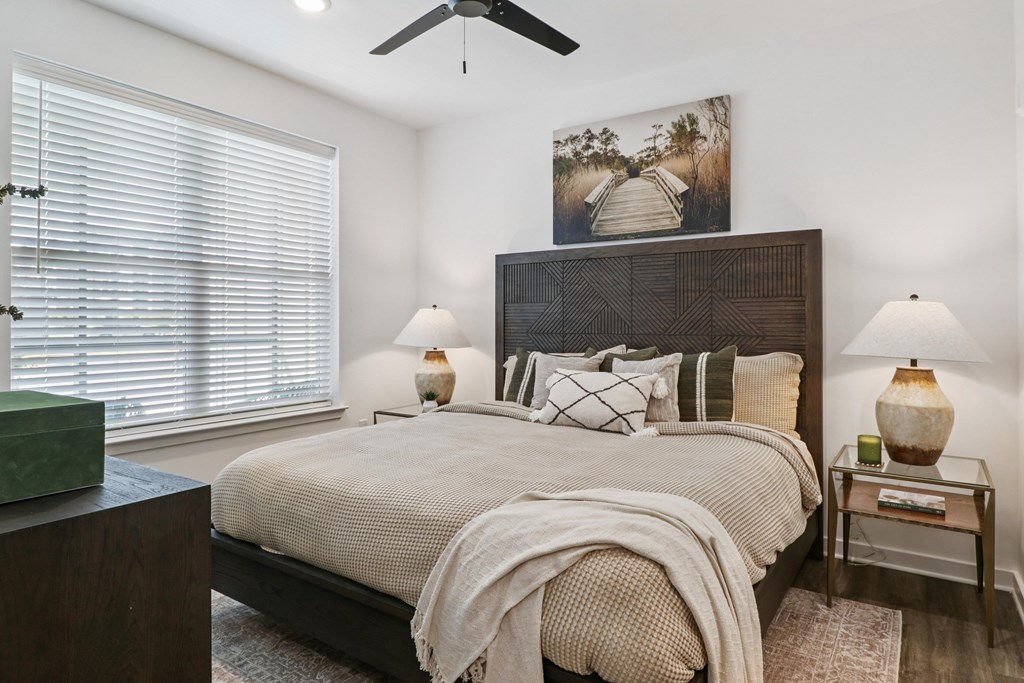 A bedroom with a large bed and a ceiling fan.