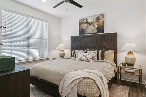 A bedroom with a large bed and a ceiling fan.
