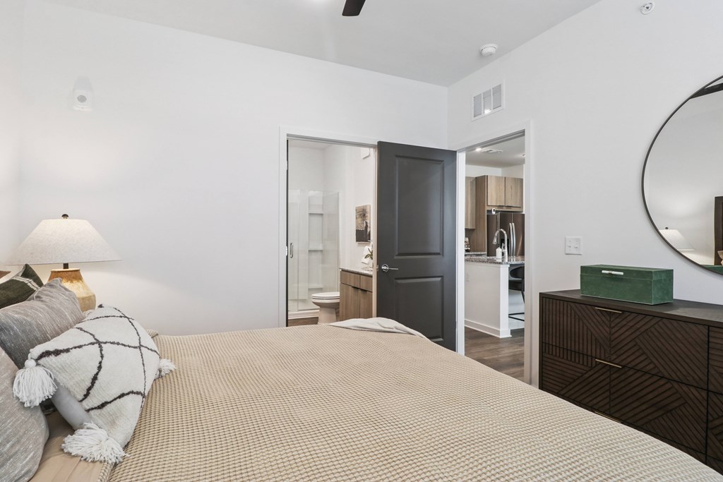 A bedroom with a bed, dresser, and mirror.