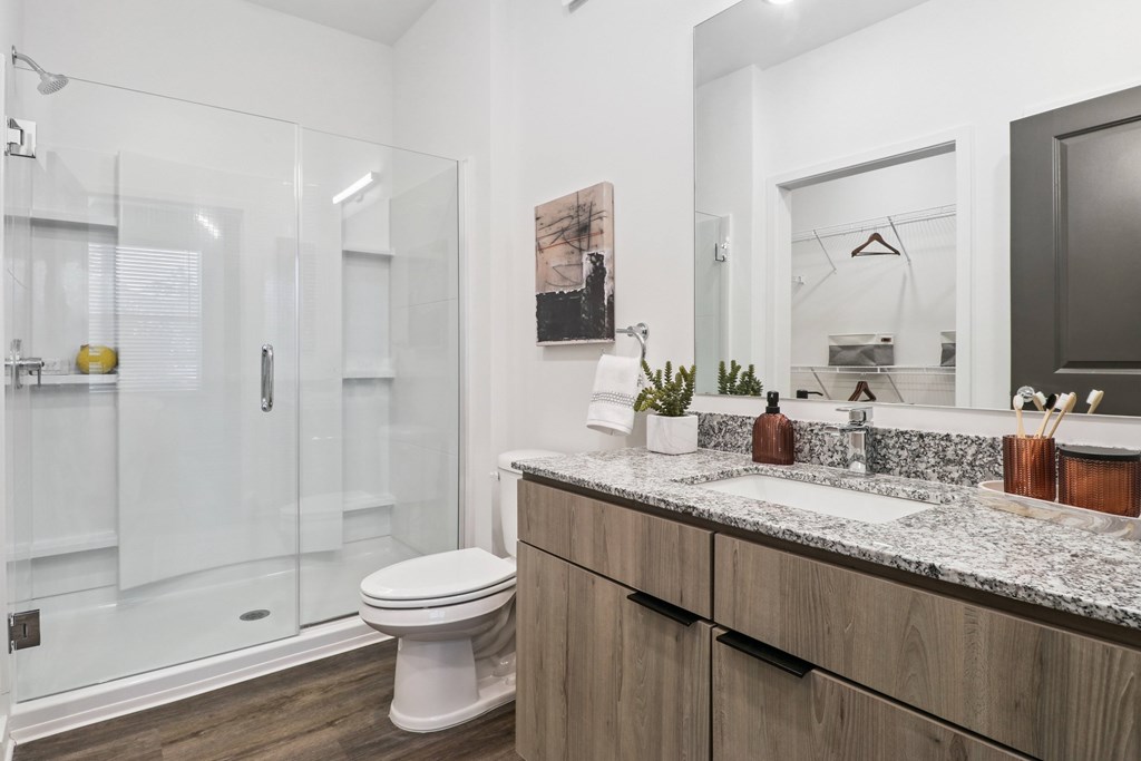 A modern bathroom with a white toilet and a marble countertop.
