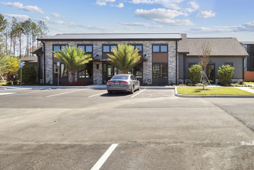 A car is parked in a parking lot in front of a building.