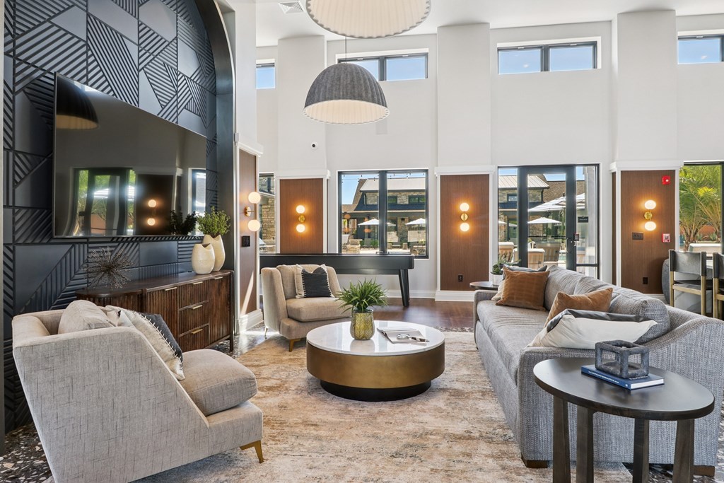 A modern living room with a grey sofa, a grey armchair, a coffee table, and a fireplace.