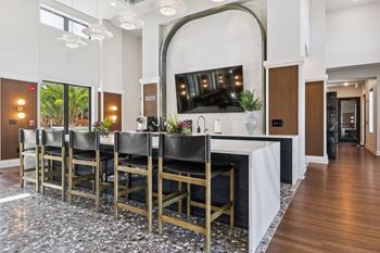 A long table with chairs is in the middle of a room with a TV on the wall.
