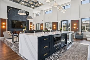 A modern kitchen with a large island and dark cabinets.