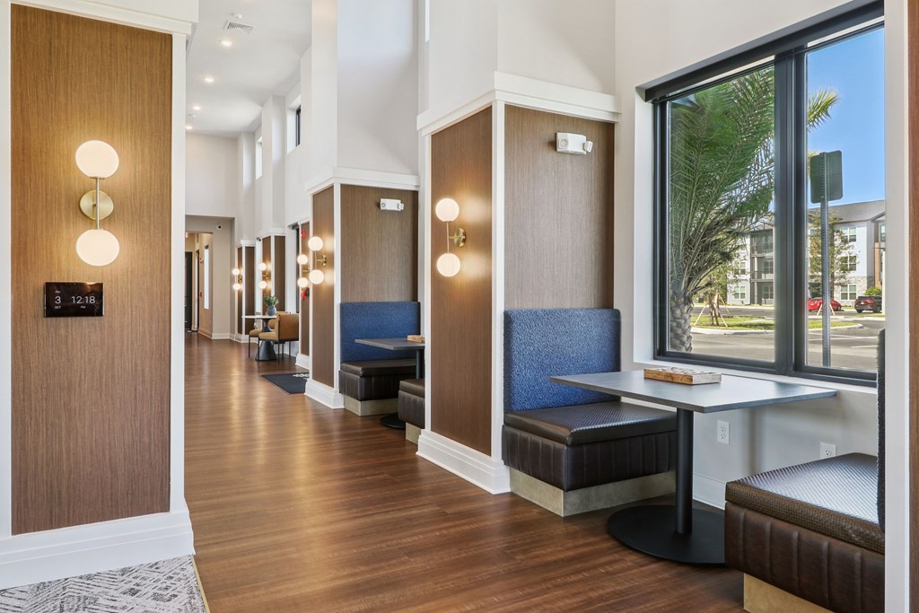 A hallway with brown wood floors and a bench with a blue cushion.