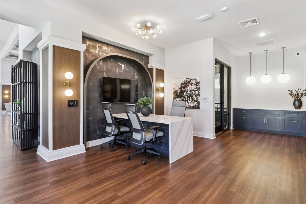 A modern office space with a wooden floor and a white reception desk.