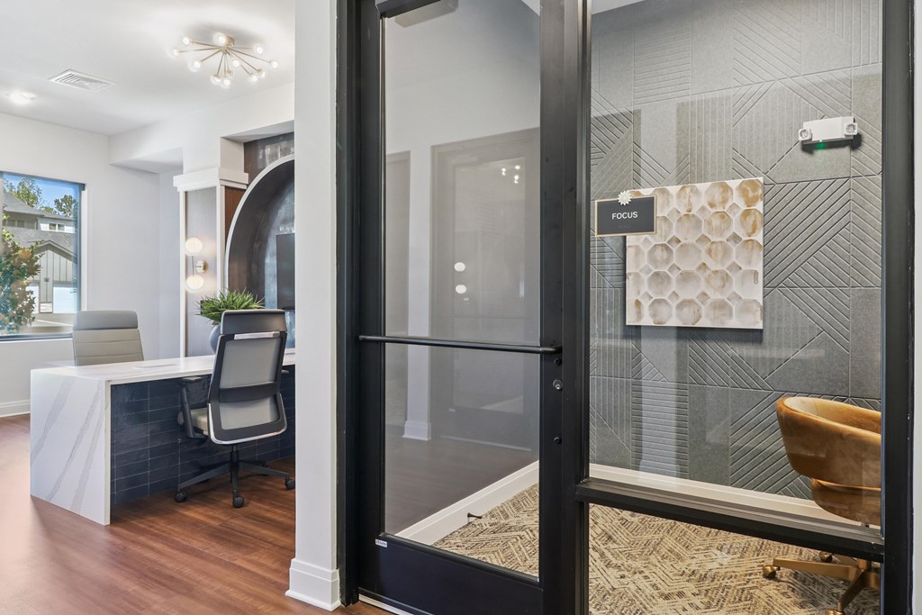 A bathroom with a glass shower door and a towel hanging on the wall.