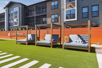 A modern building with a wooden fence and two benches in front.