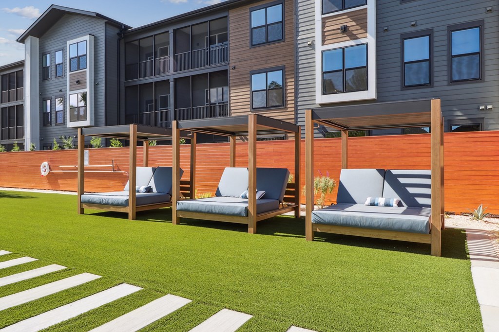 A modern building with a wooden fence and two benches in front.