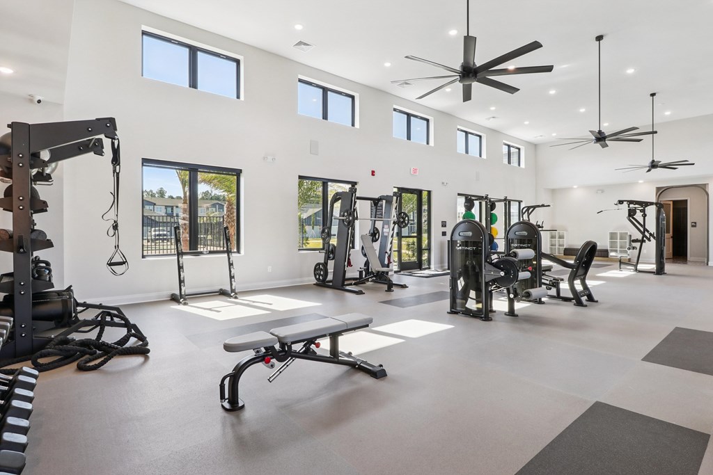 A spacious gym with a variety of equipment and a large mirror on the wall.