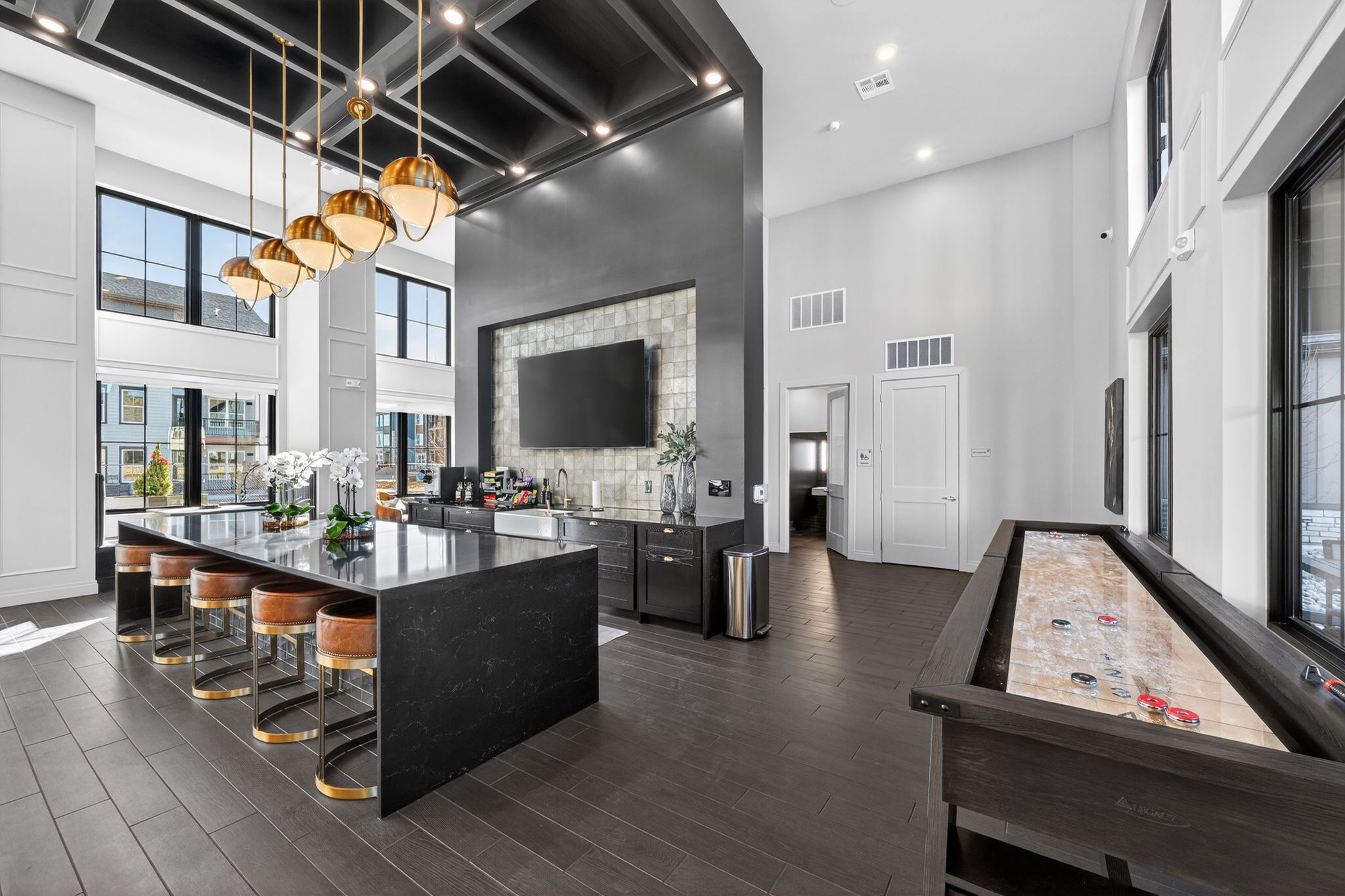 A billiard table is in the middle of a modern kitchen and dining room.