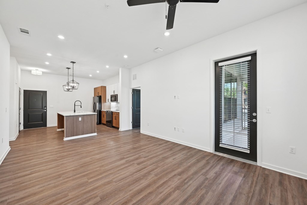 A spacious room with wooden floors and a ceiling fan at The Concord Luxury Apartments, Sarasota, FL