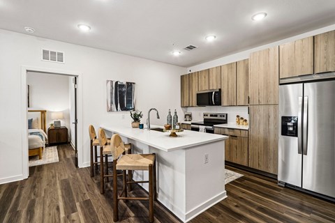 A kitchen with a white island and wooden cabinets.