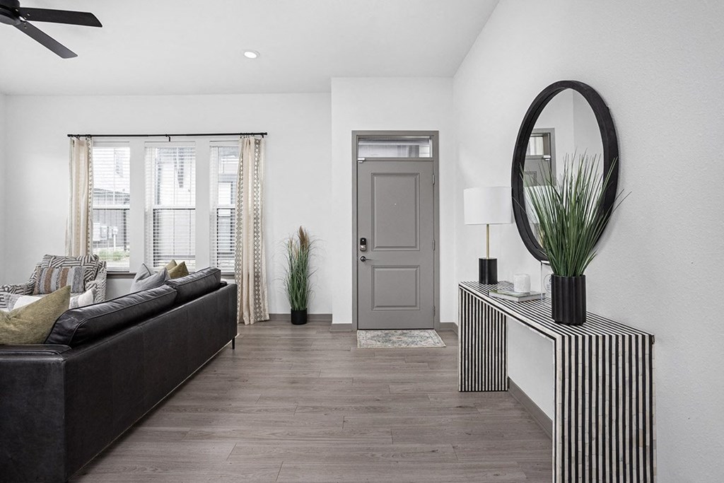 a living room with a black couch and a grey door